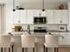 Close-up of a bright kitchen featuring white cabinets, stainless steel appliances, and light countertops at 4090 Estrella St, Brighton, CO 80601