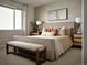 Serene primary bedroom with a large bed, bedside tables, and a bench at the foot of the bed at 4090 Estrella St, Brighton, CO 80601