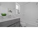 Well lit bathroom featuring a shower and tub combo along with a gray vanity and neutral countertops at 8711 E Hampden Ave # 6, Denver, CO 80231