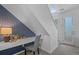 Stylish home office nook under the stairs, featuring a built-in desk, accent wall, and modern decor at 8711 E Hampden Ave # 6, Denver, CO 80231