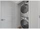 Modern laundry closet with a stacked washer and dryer, enclosed by stylish louvered doors at 8711 E Hampden Ave # 6, Denver, CO 80231