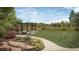 Community green space with pergola-covered seating area, fire pit, landscaping, and an expansive lawn at 5052 Nile Ct, Golden, CO 80403