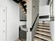 Modern staircase featuring light wood treads, black metal railings, and a sleek, minimalist design at 5052 Nile Ct, Golden, CO 80403