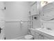 Bright bathroom features a toilet, vanity with sink, mirror, and an adjacent shelf unit for storage at 1038 E 4Th Ave, Denver, CO 80218