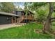 Home exterior with a wooden porch, green lawn, and mature trees at 116 Monarch St, Louisville, CO 80027