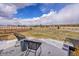 Large backyard with a wooden fence, some snow, and two black chairs on the patio at 6736 S Flanders Ct, Aurora, CO 80016