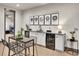 Stylish wet bar featuring modern cabinetry, a wine refrigerator, and stadium artwork above at 6736 S Flanders Ct, Aurora, CO 80016