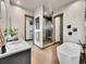 The bathroom features a modern glass shower, a soaking tub, and a vanity with a sink, blending style and functionality at 6736 S Flanders Ct, Aurora, CO 80016