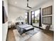 This bedroom features large windows with dark curtains, mountain wall art, a gray accent chair, and a modern rug at 6736 S Flanders Ct, Aurora, CO 80016