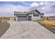 Long concrete driveway leads up to the three car garage with a gray facade at 6736 S Flanders Ct, Aurora, CO 80016