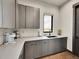 Modern kitchenette features gray cabinets, a white countertop, a sink, and a window with a scenic view at 6736 S Flanders Ct, Aurora, CO 80016