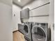 Well-equipped laundry room with modern washer and dryer, stylish gray cabinets, and ample counter space at 6736 S Flanders Ct, Aurora, CO 80016