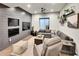 This cozy living room boasts a large gray sectional, a media wall with multiple screens, and stylish decor for relaxation at 6736 S Flanders Ct, Aurora, CO 80016