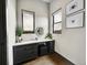 Well-lit vanity area with modern cabinets, a circular mirror, and decorative accents at 6736 S Flanders Ct, Aurora, CO 80016