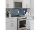 Kitchen with stainless steel appliances and blue tile backsplash at 3109 W Bates Ave, Denver, CO 80236