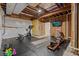 Unfinished basement workout area with rubber flooring, exposed beams, exercise equipment and TV at 731 Weston Rd, Larkspur, CO 80118