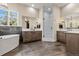 Bright bathroom features a soaking tub, dual vanities, walk-in shower, and hardwood floors at 731 Weston Rd, Larkspur, CO 80118