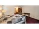 Cozy bedroom features a patterned quilt bed, desk, and view to attached bathroom at 18680 Arrowwood Dr, Monument, CO 80132
