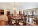 Well-lit dining area with an oval wood table, six chairs, hardwood floors, and a large picture window at 18680 Arrowwood Dr, Monument, CO 80132