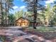 Inviting home exterior with an attached garage, nestled among tall trees, a long driveway, and a tranquil wooded lot at 18680 Arrowwood Dr, Monument, CO 80132