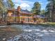 Beautiful home featuring a spacious deck and large windows for natural light surrounded by trees, snow and blue skies at 18680 Arrowwood Dr, Monument, CO 80132