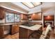 Charming kitchen featuring wood cabinets, granite countertops, a center island with cooktop, and eat-in seating at 18680 Arrowwood Dr, Monument, CO 80132
