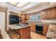 Functional kitchen with wooden cabinets, granite countertops, a center island with a cooktop and an eat-in bench at 18680 Arrowwood Dr, Monument, CO 80132