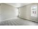 Inviting bedroom features plush carpet, two windows providing natural light, and neutral paint throughout the space at 1050 S Monaco Pkwy # 125, Denver, CO 80224