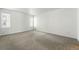 Bright bedroom features neutral carpet, white walls, and natural light from two windows at 1050 S Monaco Pkwy # 125, Denver, CO 80224