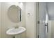 This stylish powder room includes a pedestal sink, large decorative mirror, and modern fixtures and design at 1050 S Monaco Pkwy # 125, Denver, CO 80224