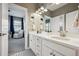 Bathroom featuring double sinks, white cabinets, and a view into the Bedroom at 21854 Tyrolite Ave, Parker, CO 80138