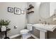 Cozy powder room with pedestal sink, decorative shelves, and charming artwork at 21854 Tyrolite Ave, Parker, CO 80138