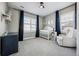 Cozy Bedroom featuring a crib, glider, and dark blue accent curtains at 21854 Tyrolite Ave, Parker, CO 80138