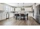 Well-lit kitchen featuring white cabinets, a center island with seating, and stainless steel appliances at 21854 Tyrolite Ave, Parker, CO 80138