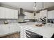 Well-lit kitchen with a large island, pendant lights, white countertops, and stylish backsplash at 21854 Tyrolite Ave, Parker, CO 80138