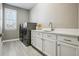 Functional laundry room with modern washer and dryer, white cabinets, and ample counter space at 21854 Tyrolite Ave, Parker, CO 80138