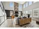 Bright living room with stone fireplace, hardwood floors, and many windows with plantation shutters at 21854 Tyrolite Ave, Parker, CO 80138