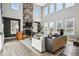 Spacious living room with a stone fireplace, tall windows, and modern furnishings at 21854 Tyrolite Ave, Parker, CO 80138