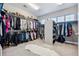 Spacious walk-in closet with ample hanging space, shelving, and a plush rug at 21854 Tyrolite Ave, Parker, CO 80138