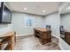 Functional office space with sleek desk, wood-look flooring, natural light from the large window, and mounted TV at 1537 Rosedale St, Castle Rock, CO 80104