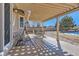Inviting covered patio with dining set, swing, and view of the well-maintained yard at 1537 Rosedale St, Castle Rock, CO 80104
