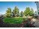 Manicured backyard with lawn, mature trees, and decorative landscaping, providing a peaceful outdoor setting at 2861 Eagle Cir, Erie, CO 80516