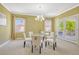 Bright dining room with a glass table and white chairs, illuminated by a modern chandelier at 2861 Eagle Cir, Erie, CO 80516