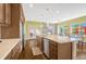 Gourmet kitchen featuring wood cabinets, stone counters, a center island with bar seating and a stone fireplace at 2861 Eagle Cir, Erie, CO 80516