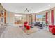 Comfortable living room featuring a stone fireplace, carpet flooring, and large windows at 2861 Eagle Cir, Erie, CO 80516