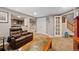 Cozy basement featuring a leather sofa, neutral paint, carpet, and glass paneled doors at 5706 S Garland Way, Littleton, CO 80123