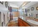 Well-lit bathroom featuring a double vanity, tiled floors, and a bathtub with shower at 5706 S Garland Way, Littleton, CO 80123