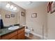 Well-lit bathroom with framed art, dark granite countertop, vanity, mirror, and a modern white toilet at 5706 S Garland Way, Littleton, CO 80123