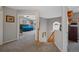 Carpeted hallway leads to a bedroom with vaulted ceilings, a ceiling fan, and large windows at 5706 S Garland Way, Littleton, CO 80123