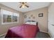 Cozy bedroom with a red quilt, a window with outside views, carpet flooring, and light-colored walls at 5706 S Garland Way, Littleton, CO 80123